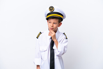 Little airplane pilot boy isolated on white background looking to the side and smiling