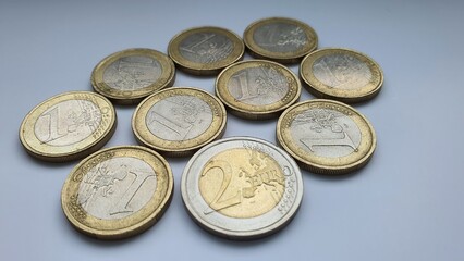 Ten old coins of one and two euro denominations on a white background close-up