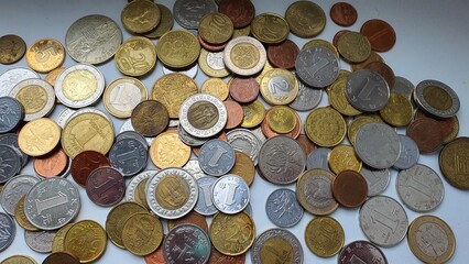 A lot of coins from different countries of the world on a white background. Euro, euro cents, Polish zloty, Polish pennies, Ukrainian hryvnia, Chinese yuan, Egyptian pounds