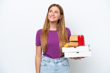 Young pretty blonde woman holding fast food isolated on white background thinking an idea while looking up