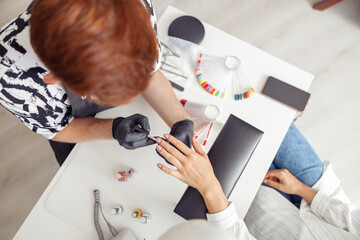 Proffesional manicure master working on nails in salon