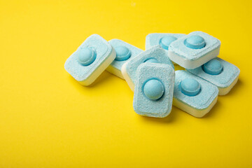 Tablets for softening water on a yellow background. Capsules for washing machines and dishwashers,...