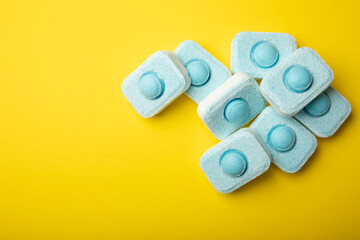 Tablets for softening water on a yellow background. Capsules for washing machines and dishwashers,...
