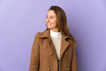 Middle age Brazilian woman isolated on purple background looking side