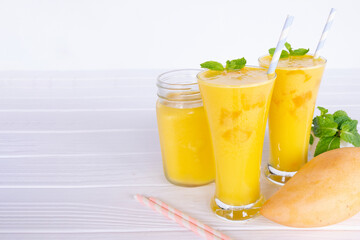Mango smoothies yellow colorful fruit juice milkshake blend beverage healthy high protein the taste yummy In glass,drink to lose weight drink episode morning on white gray background.
