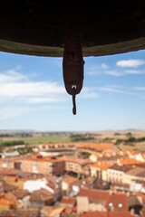 close up of a bell and its clapper seen from the top of a belfry