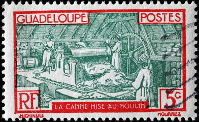 Sugar cane processing on vintage stamp from Guadeloupe