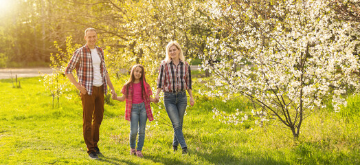 Happy family spending good time together in spring in a flowering garden