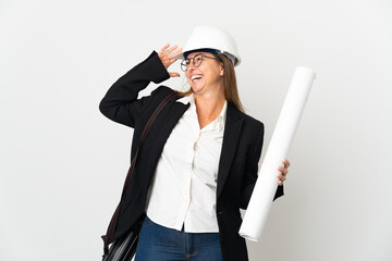 Middle age architect woman with helmet and holding blueprints over isolated background smiling a lot