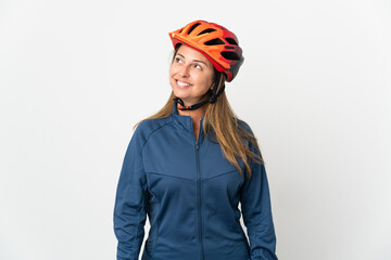 Middle age cyclist woman isolated on white background thinking an idea while looking up