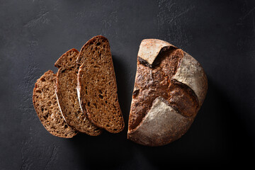 Loaf of freshly baked hemp bread on black background. View from above.
