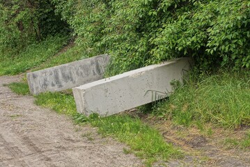 two big gray concrete blocks stands on the ground and green grass outside