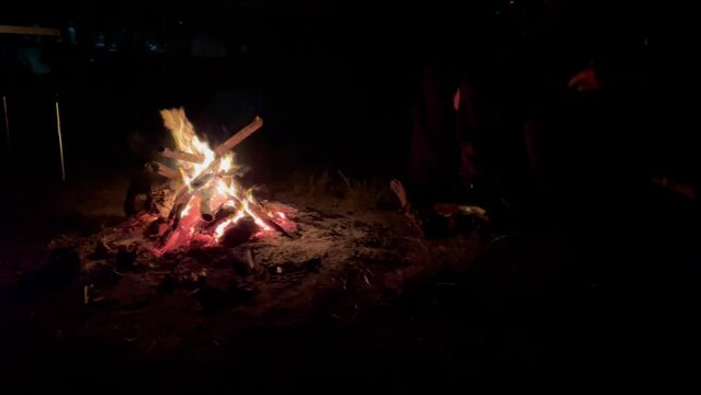 Menschen um ein Lagerfeuer beim Campen