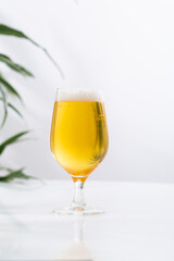 Glass with light beer and foam light background copy space