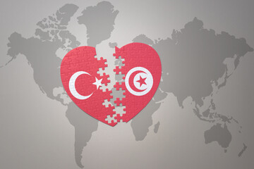 puzzle heart with the national flag of turkey and tunisia on a world map background. Concept.