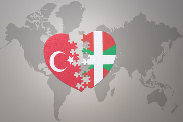 puzzle heart with the national flag of turkey and basque country on a world map background. Concept.