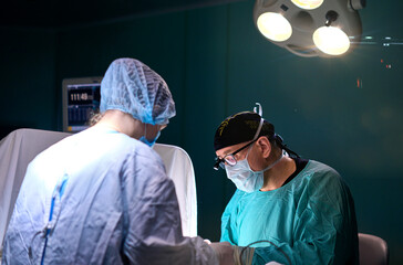 surgeon in a dark operating room during surgery