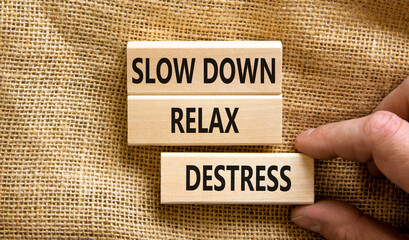 Destress symbol. Concept words Slow down Relax Destress on wooden blocks. Beautiful canvas table canvas background. Doctor hand. Psychological business slow down Relax destress concept. Copy space.