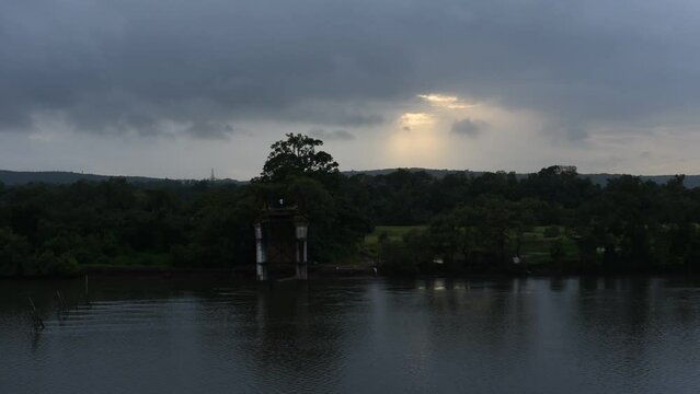 HD scenery of the Zuari river flowing through Borim village in Goa India with a view of a Chowgule Shipyard shipbuilding company and Borim Bridge