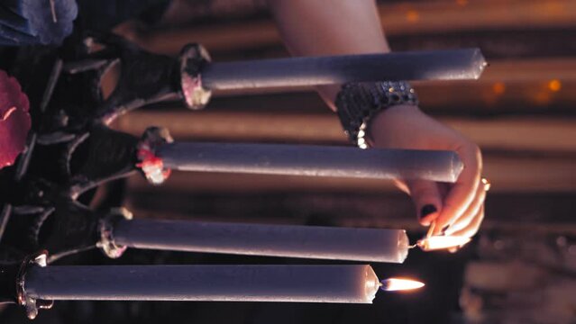 A woman's hand lights candles in an old candlestick. vertical