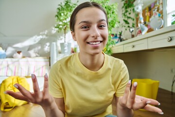 Teenage female student having video call, looking at webcam