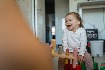 One small caucasian baby girl toddler playing in the room happy at home in day happy smile copy space