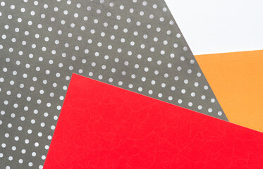 red orange and white paper interrupted by a polka dot bully shape