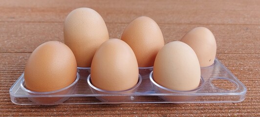 Braun chicken Eggs in basket. Brown chicken egges on wooden vintage table. Fresh egg on morning...