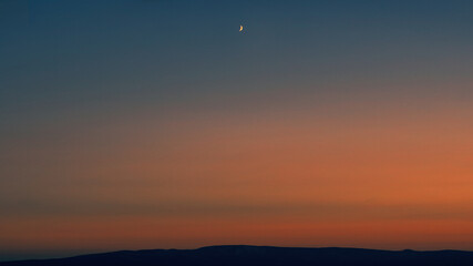 sunset over the mountains, dramatic sky, moon
