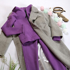 Stylish women's outfit, lilac tracksuit, gray autumn coat on a white background.
