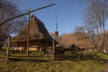 Fototapeta na wymiar An old wooden Ukrainian house with a well on the territory of the Shevchenkovsky hai park in Lviv