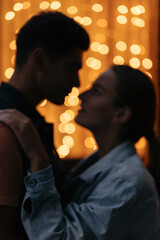  Blurred silhouette of a couple on a background of garlands. Blur