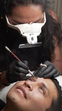Makeup artist with gloves making microblading procedure