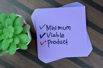 Concept of Minimum Viable Product write on sticky notes isolated on Wooden Table.