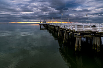 Fototapeta premium Pier on the sea coast and stormy sky