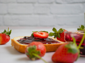 Strawberry jam in a glass of bread on an old background