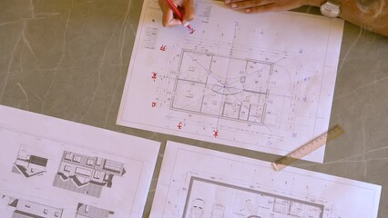 TOP DOWN: Young female finishing feng shui house plan for energy flow analysis. Young woman analysing energy distribution for well balanced feng shui interior design arrangement of residential house