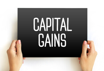 Capital gains - increase in a capital asset's value and is realized when the asset is sold, text concept on card