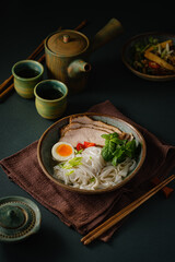Asian noodle soup on table, ramen with pork, vegetables and egg in a bowl. Copy space - 507381064