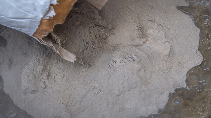 Construction worker pouring the cement to the bucket. Adhesive mixing. Waiting to be mixed with cement.