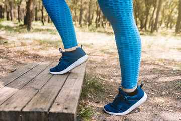 close up of legs of young sportswoman, doing aerobic exercises outdoors. sporty woman jumping. health and wellness lifestyle.