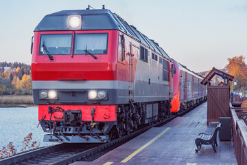 Highspeed train stands by the wooden platform at sunset. Sortavala. Republic of Karelia.