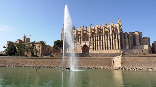 Parc de la Mar and Santa Maria Cathedral in Palma de Mallorca with pond and fountain in the foreground - Spain