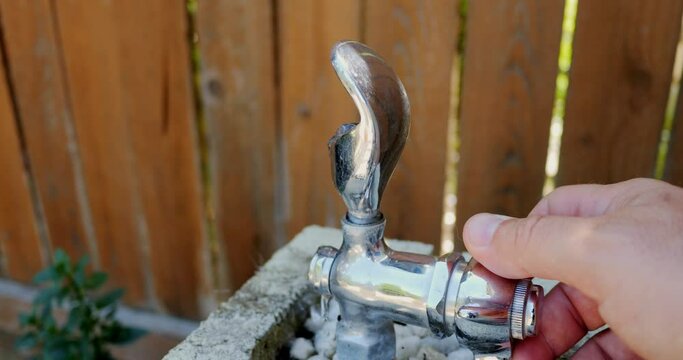 Turning on a chrome water fountain in slow motion
