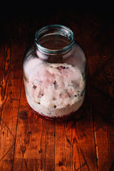 Jar of rye bread and hibiscus homemade kvass, kvas in process of making, High foam from sugar and yeast, rustic background. Top view