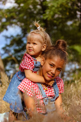 Cute sisters happy together. Children smiling celebrating Children's Day June 1 outdoors. Kids activities, education, holiday on nature. Kids have fun in park, forest. Safety, welfare, love of babies.