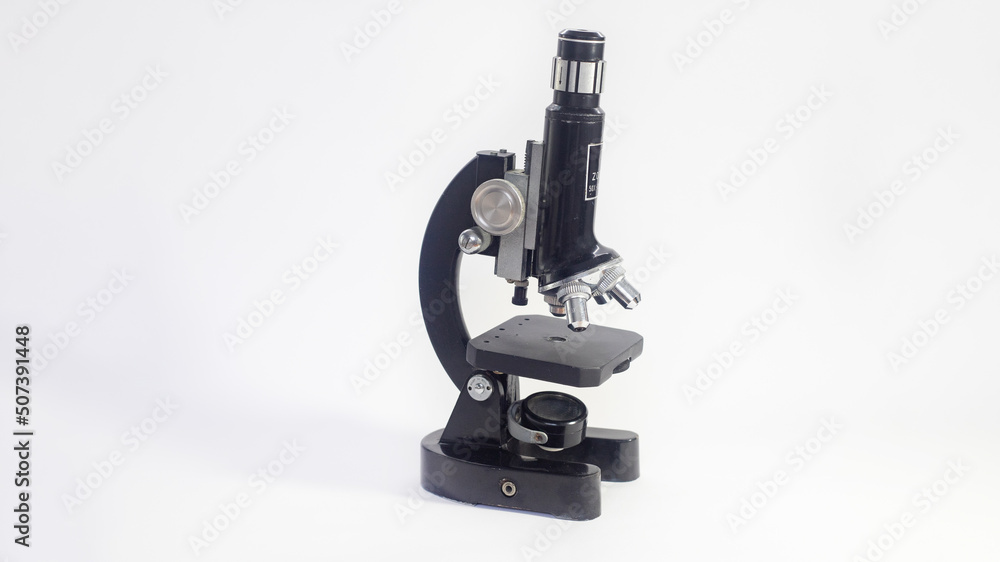 Wall mural old analog microscope, mirror on white background with copy space