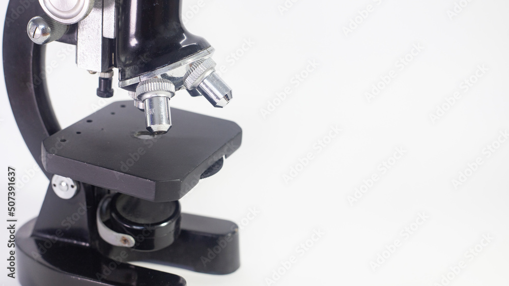 Wall mural old analog microscope, mirror on white background with copy space