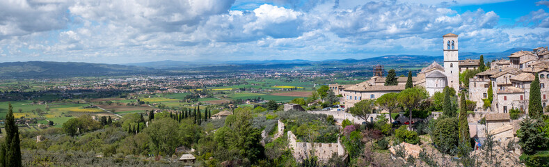 Fototapeta na wymiar Wide panorama of the ancient houses and countryside surrounding the city of Assisi (Umbria Region, central Italy). Is world famous as birthplace of St. Francis, Italy's christian Patron.