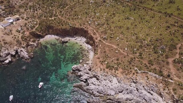 Aerial drone view above the beautiful coastline, turquoise clear sea water and wild nature of Zingaro Nature Reserve, Sicily. Tropical travel holiday destination in Europe near Scopello in Italy.